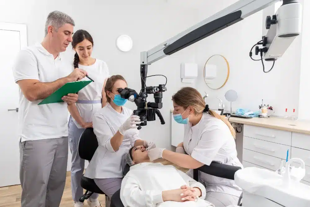 A dental team doing a checkup on a patient and teaching her How To Strengthen Your Teeth.