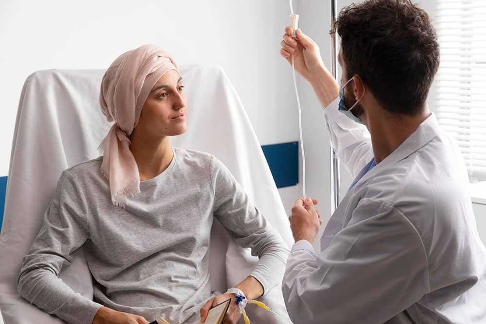 A woman undergoing chemotherapy discussing Oral Health and Breast Cancer with her doctor. 