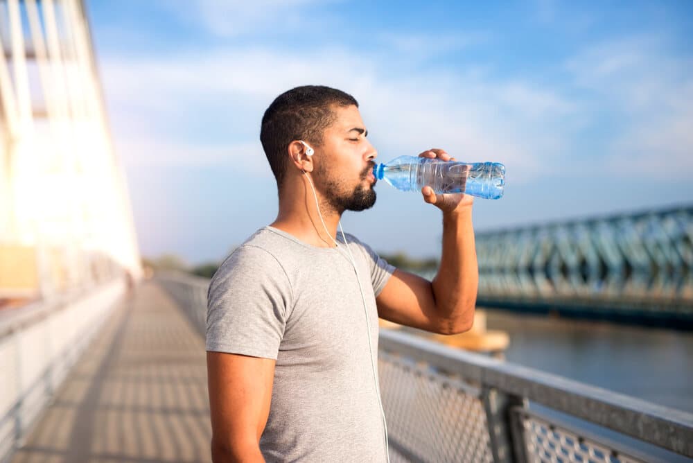 A man drinking water so he can stay Hydrated.