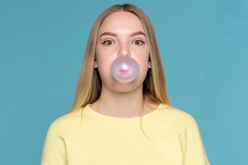 A woman chewing sugar free gum made with xylitol.