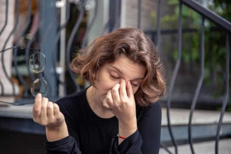 A lady experiencing dry eyes, one of the more common Sjögren's syndrome symptoms.