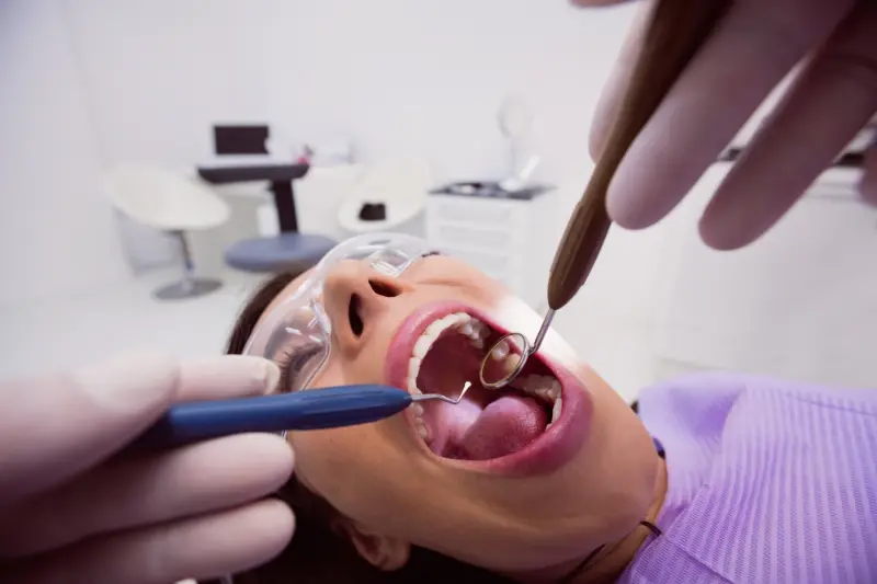A woman at the dentist being examined to determine if she has early-stage Periodontal Disease.